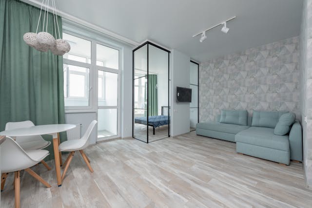 living room with hardwood floors a blue couch and a white table